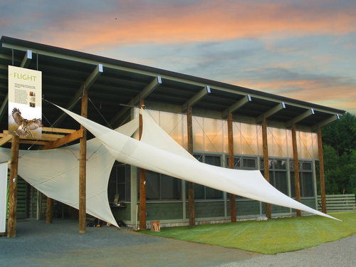 Modern building with large white fabric sails at sunset.